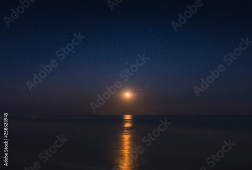 Full moon reflected in the starry night in the waves of the sea © Paraschiv