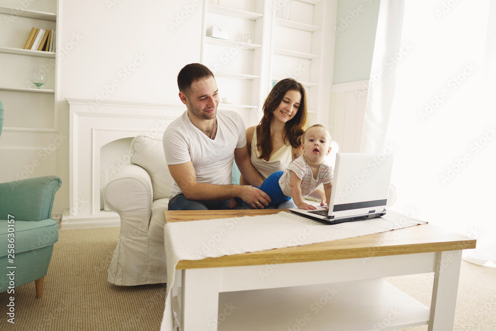 Loving parents sitting in living room at home laughing playing developing game with their little baby son. Childhood, parenthood, child development, togetherness, love, happiness concept Loving parents sitting in living room at home laughing playing developing game with their little baby son. Childhood, parenthood, child development, togetherness, love, happiness concept