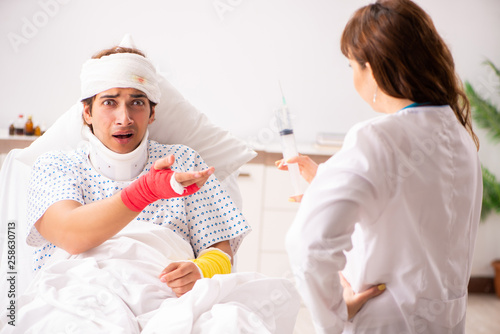 Young doctor examining injured patient 