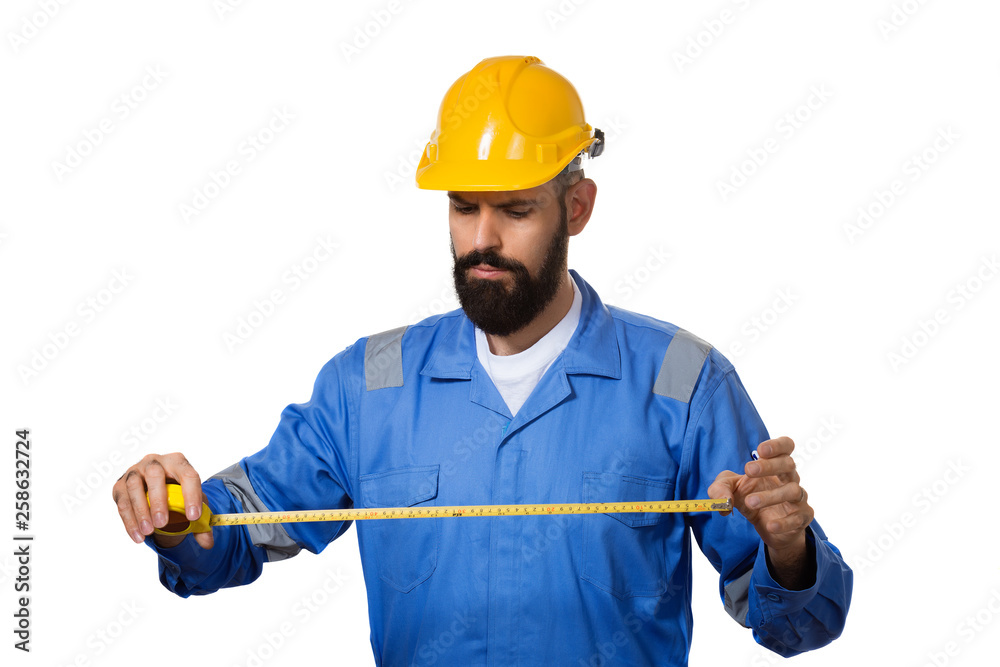 Handsome builder with beard is holding tape-measure in his hands. Isolated on white Handsome builder with beard is holding tape-measure in his hands. Isolated on white