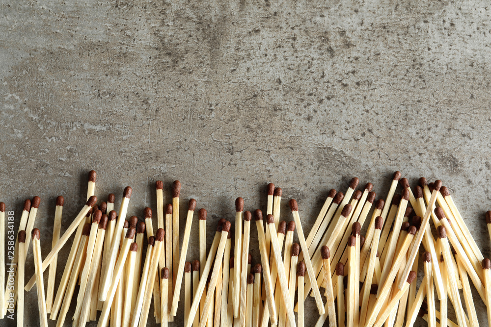 Many matches on grey background, top view with space for text Many matches on grey background, top view with space for text