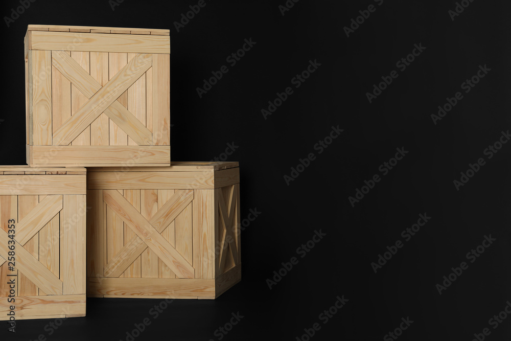 Wooden crates on black background, space for text. Shipping containers Wooden crates on black background, space for text. Shipping containers