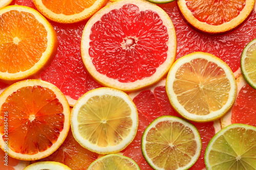 Slices of fresh citrus fruits as background  top view
