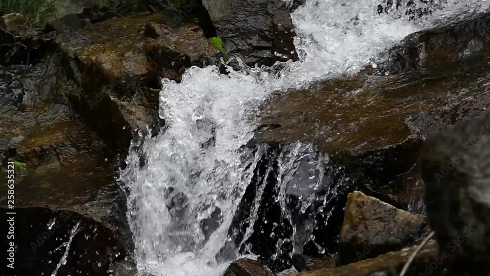 Slow motion video of a small waterfall among the rocks Slow motion video of a small waterfall among the rocks