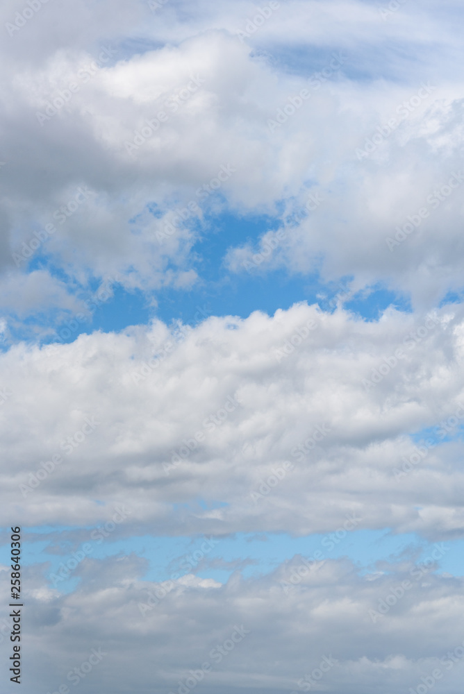Peaceful nature background with stripes of white fluffy clouds and blue sky Peaceful nature background with stripes of white fluffy clouds and blue sky