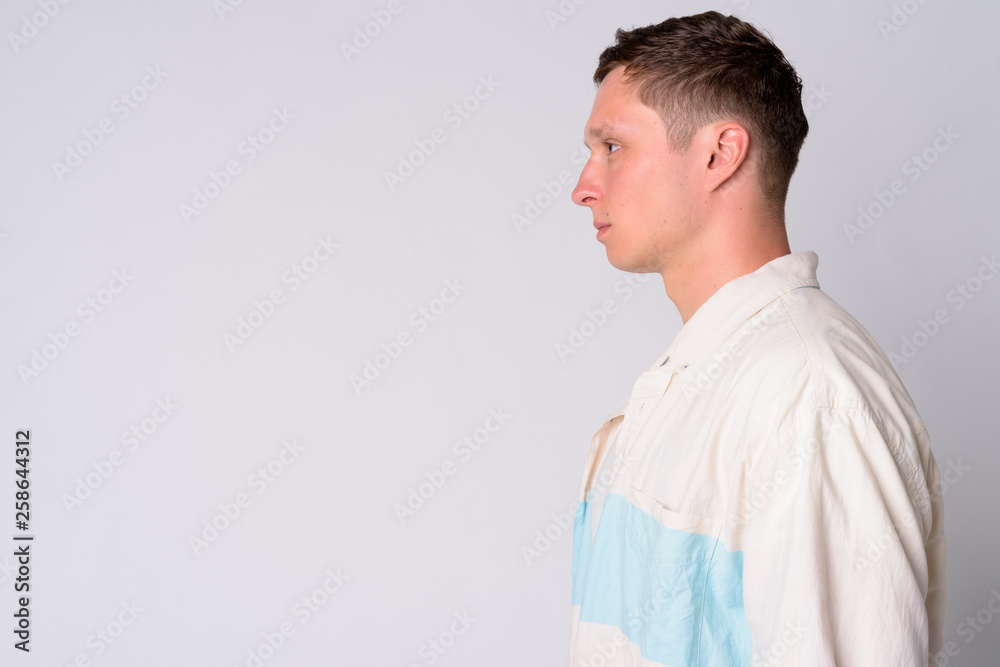 Profile view of young man against white background Profile view of young man against white background