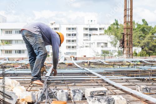 Worker install wire on building floor for tower under construction site.