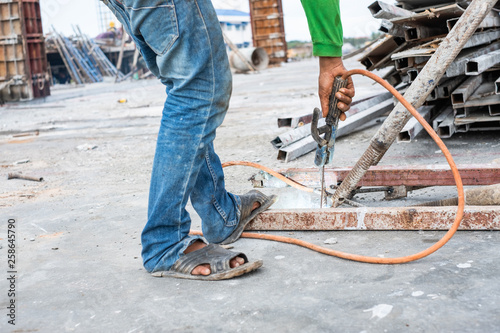 Welder worker welding steel structure outdoor at building construction site without protection. © phoderstock