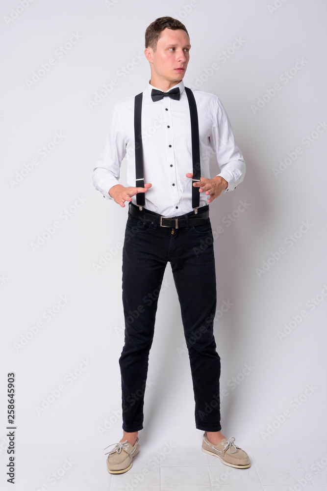 Full body shot of young businessman with suspenders thinking Full body shot of young businessman with suspenders thinking