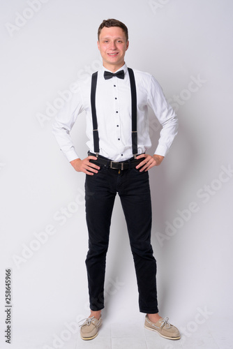 Full body shot of happy young businessman with suspenders smiling © Ranta Images