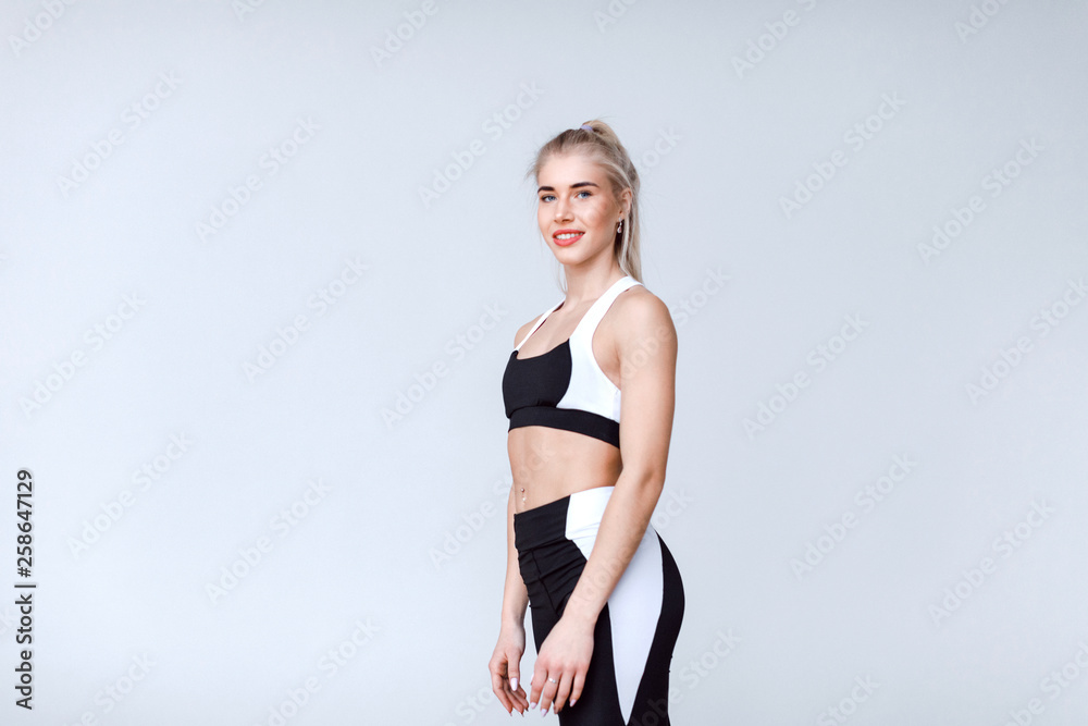 Beautiful woman in sportswear on a gray.