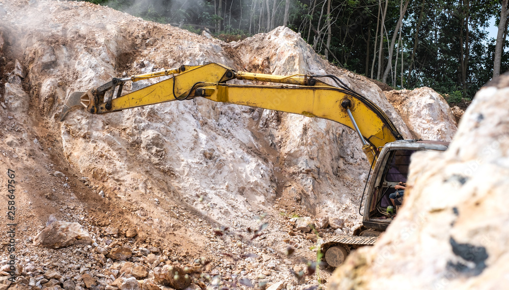 Large hydraulic Jackhammer working on smashing rock. Large hydraulic Jackhammer working on smashing rock.