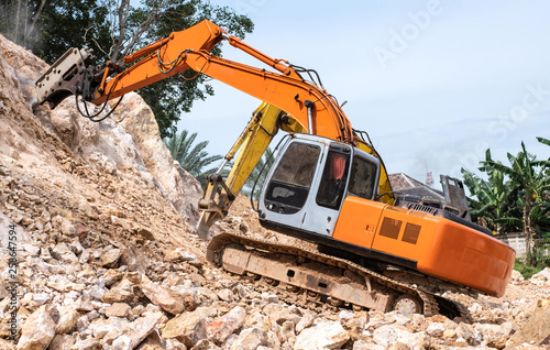 Large hydraulic Jackhammer working on smashing rock.