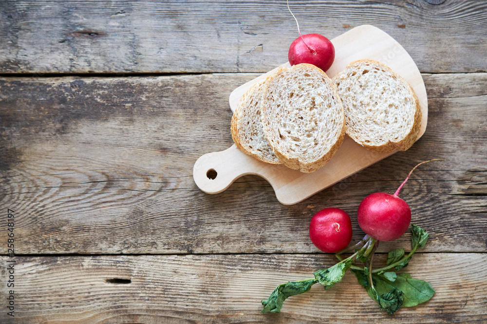 Fresh radish with slices of bread on a wooden background Fresh radish with slices of bread on a wooden background