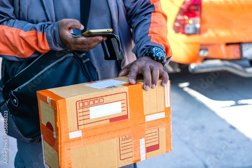 Young modern delivery man using smartphone on delivery work time. © phoderstock
