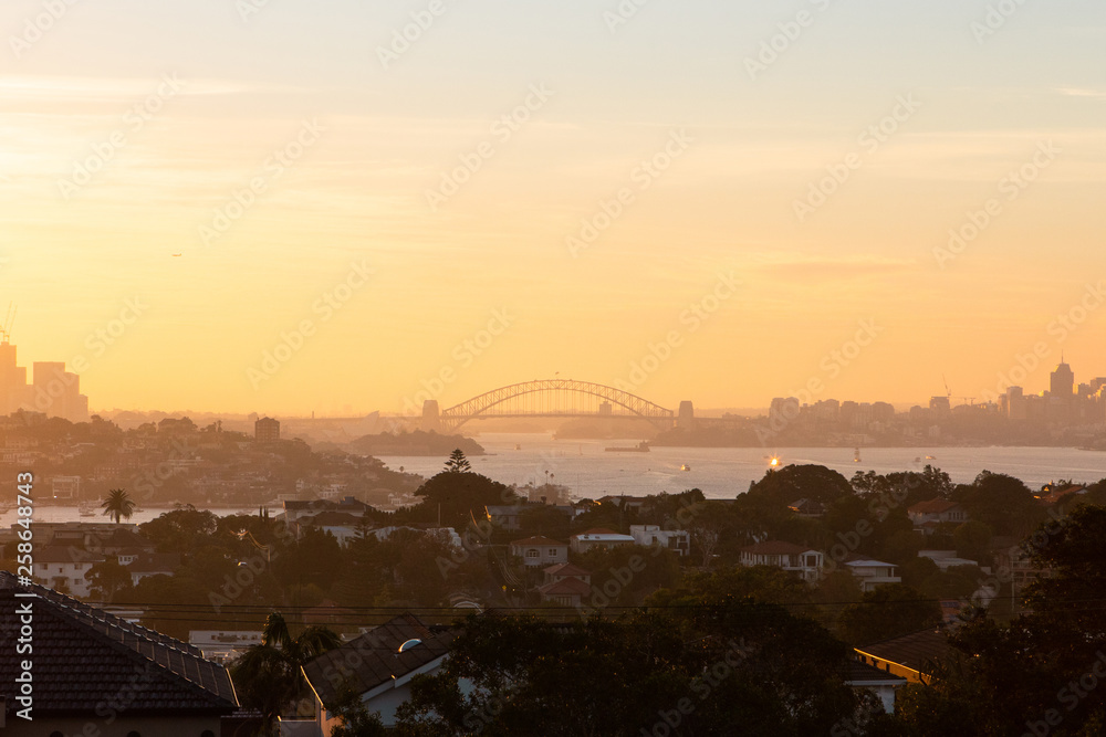 Sydney Harbour bridge at the distance under the sunset light.
