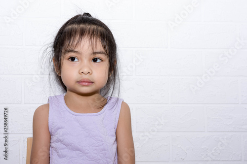 Female asian child girl sitting on a chair with white background