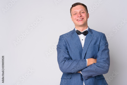Portrait of happy young businessman with suit smiling and crossing arms