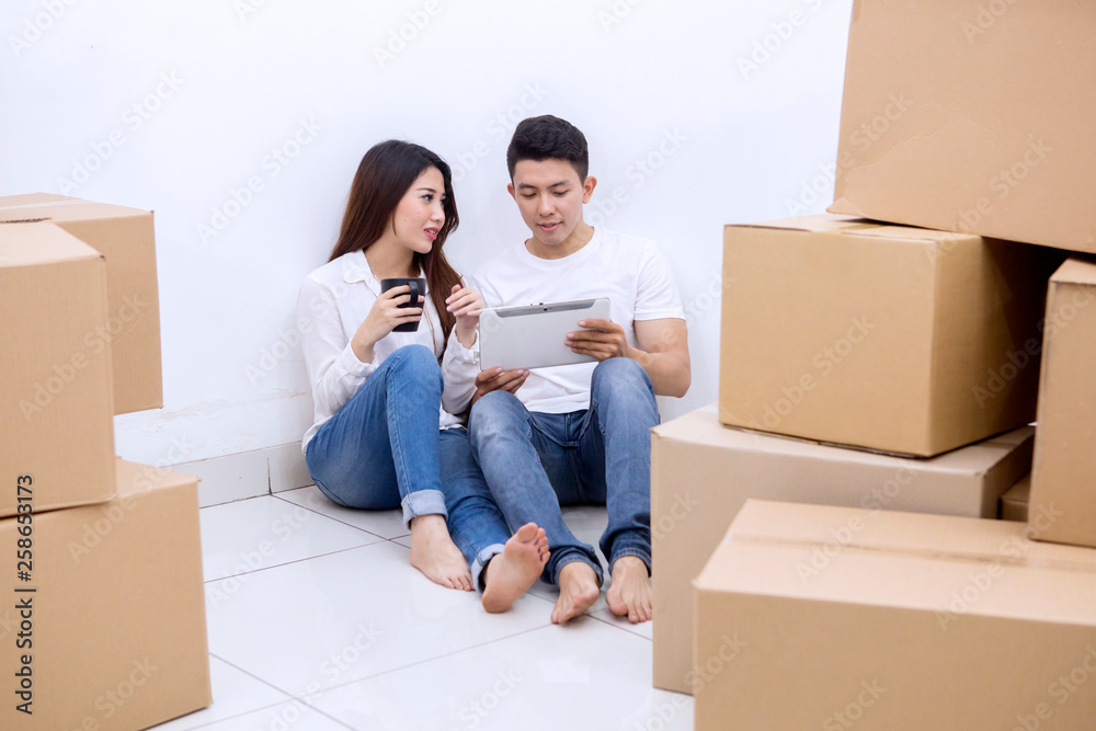 Asian couple rests during moving into new house Asian couple rests during moving into new house