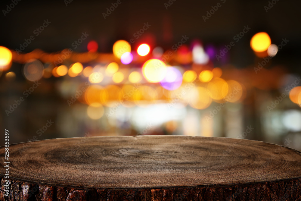 Image of wooden table in front of abstract blurred restaurant lights background - obrazy, fototapety, plakaty 