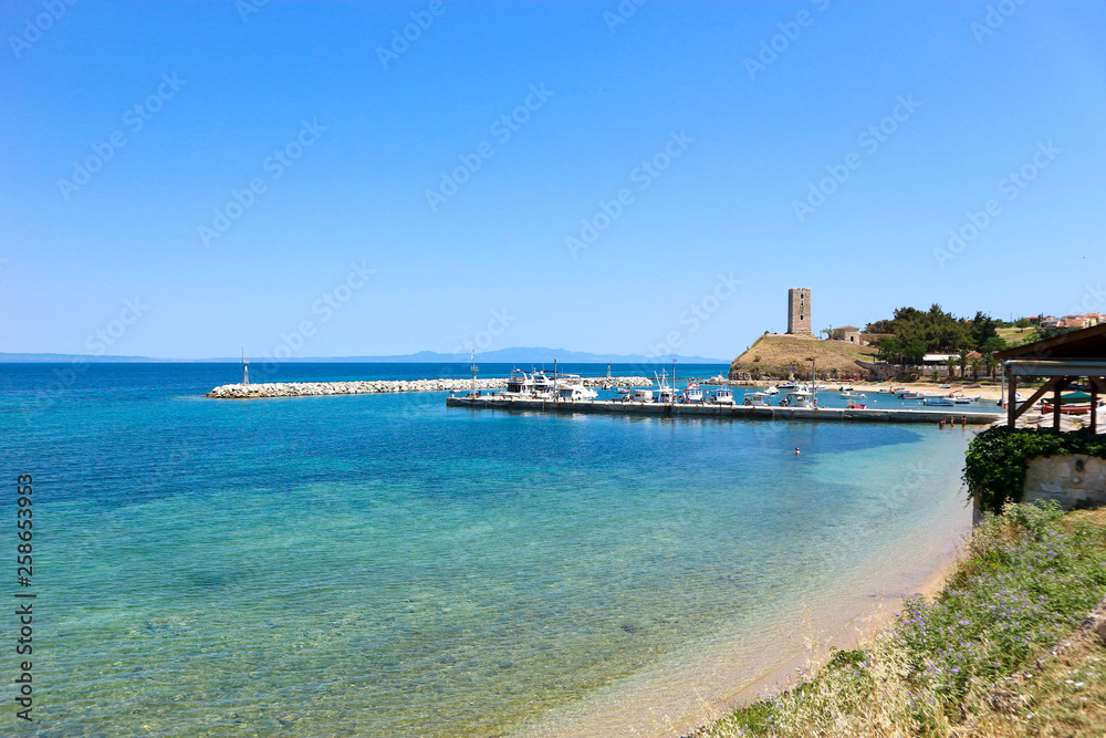 Panoramic view to the port of Nea Fokea, Mediterranean sea, Greece with old byzantine tower on the background