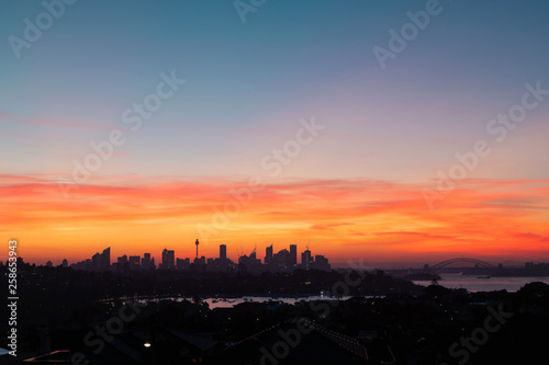 Sydney skyline with red orange sunset sky.