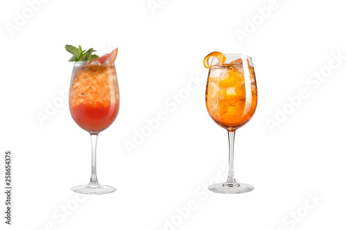 Alcohol cocktail with mint, fruit and berries on a white background. A set of two cocktails in glass goblets on a long leg.