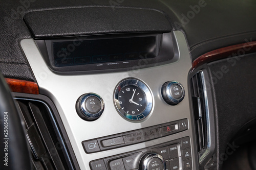 View to the interior of car with dashboard, clock, media system after cleaning before sale on parking
