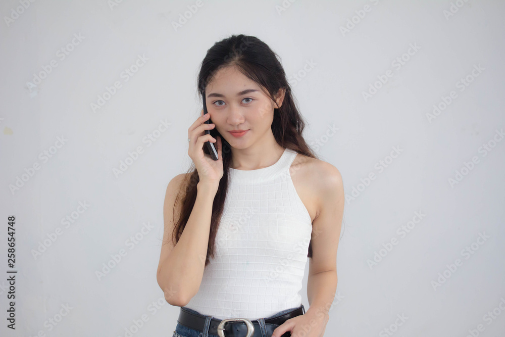 Portrait of thai china adult beautiful girl White shirt blue jeans calling smart phone Portrait of thai china adult beautiful girl White shirt blue jeans calling smart phone