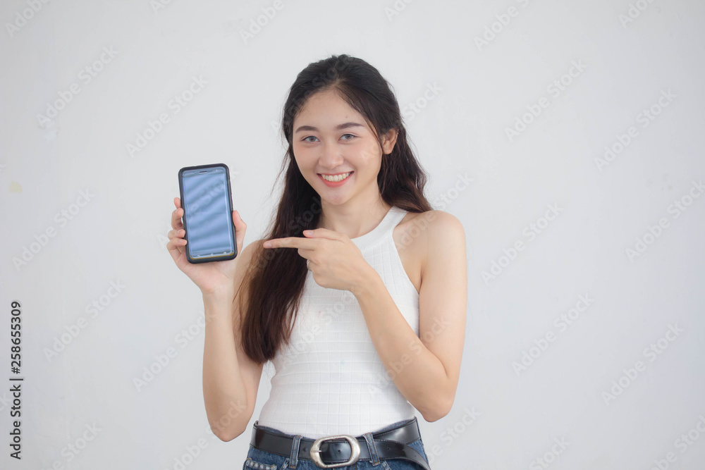 Portrait of thai china adult beautiful girl White shirt blue jeans show her smart phone Portrait of thai china adult beautiful girl White shirt blue jeans show her smart phone