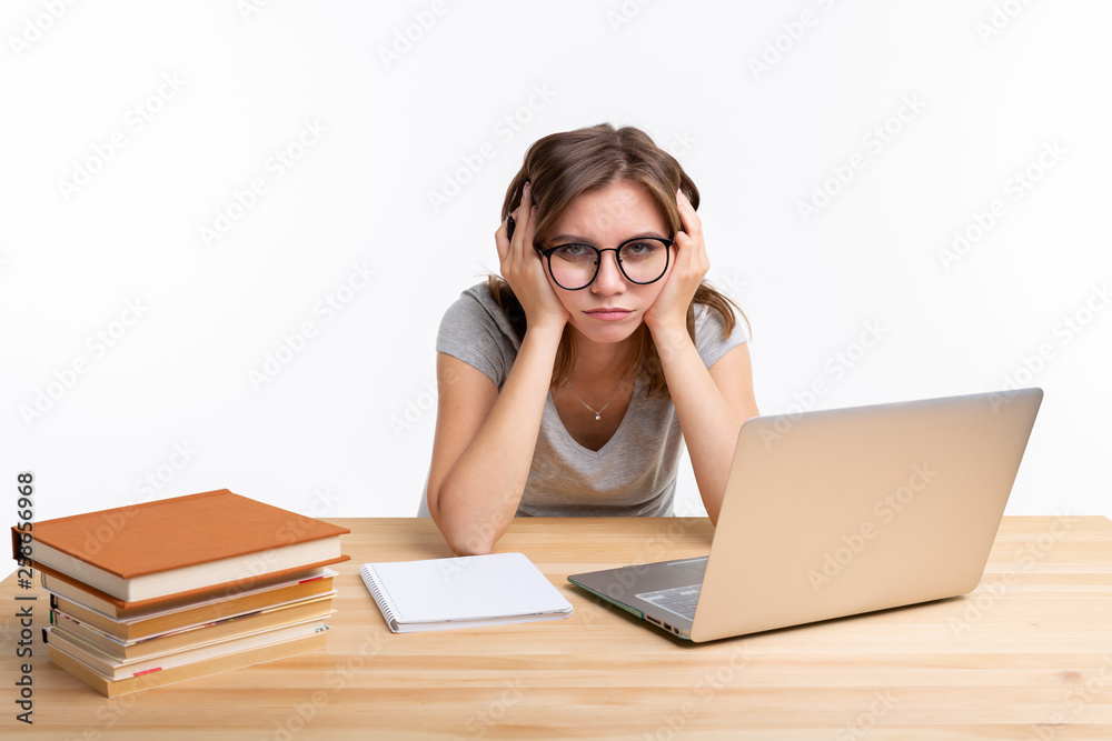 Study, education and people concept - young student woman working at laptop looking very tired Study, education and people concept - young student woman working at laptop looking very tired