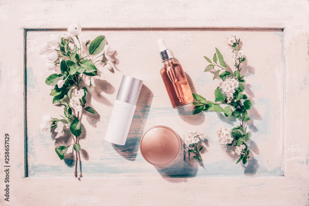 Natural organic cosmetics: serum, cream, mask on wooden background with flowers. Skincare concept - obrazy, fototapety, plakaty 
