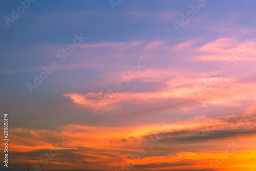 Sky blue and orange, pink light of the sun through the clouds in the sky © prasith