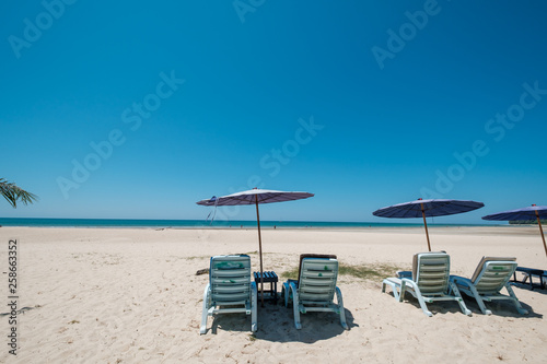 Sunbeds on tropical beach with calm sky. sea view and sand beach  summer background.