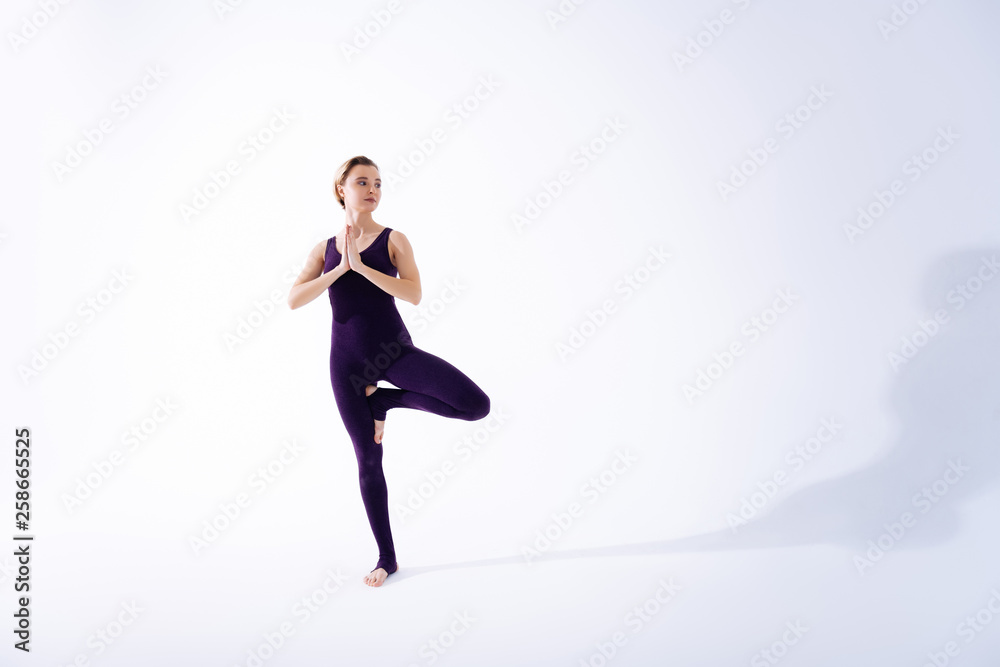 Positive slim woman pressing one leg to another