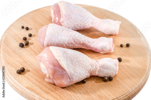 chicken legs on wooden board isolated on white background