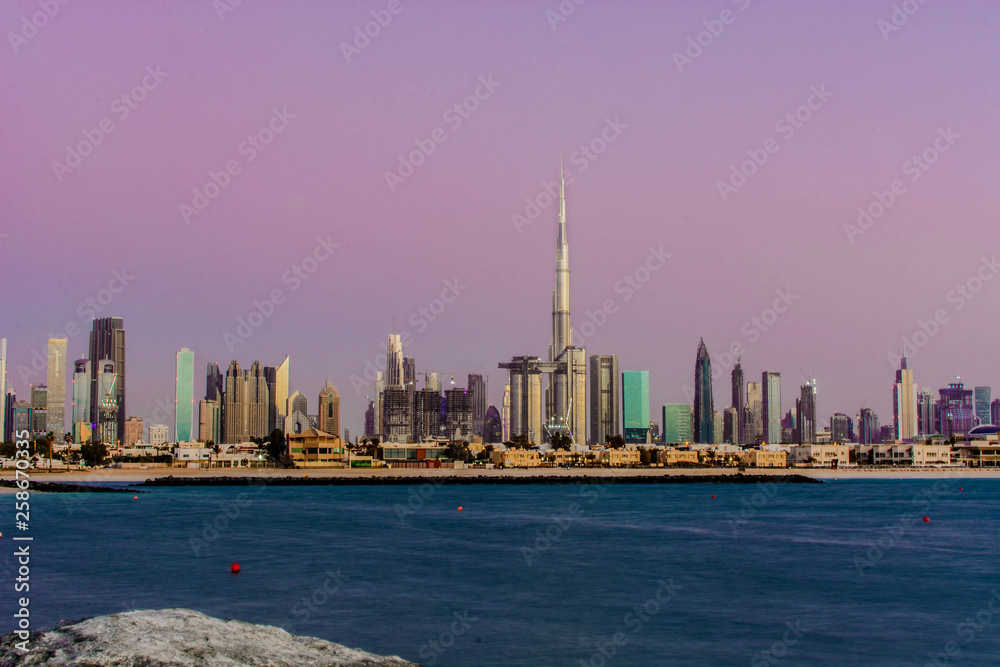Futuristic Skyscraper buildings view from beach island with blue waterfront and  twilight sky background