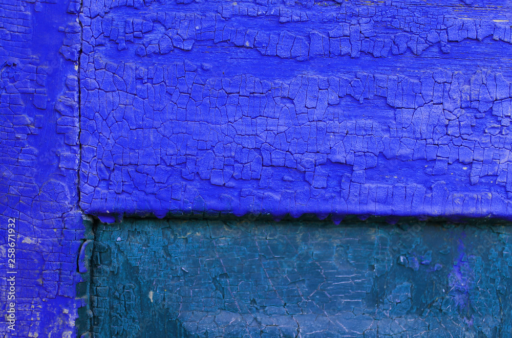 Naklejka premium Old wooden background with remains of pieces of scraps of old paint on wood. Texture of an old tree, vintage wood background peeling paint. old blue board with cracked paint