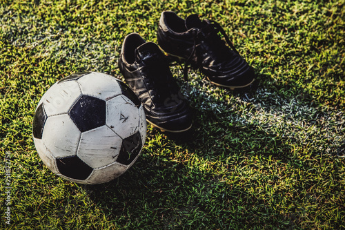 soccer ball and boots on green grass