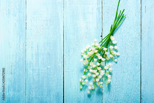 lily of the valley flowers on blue painted wood table background