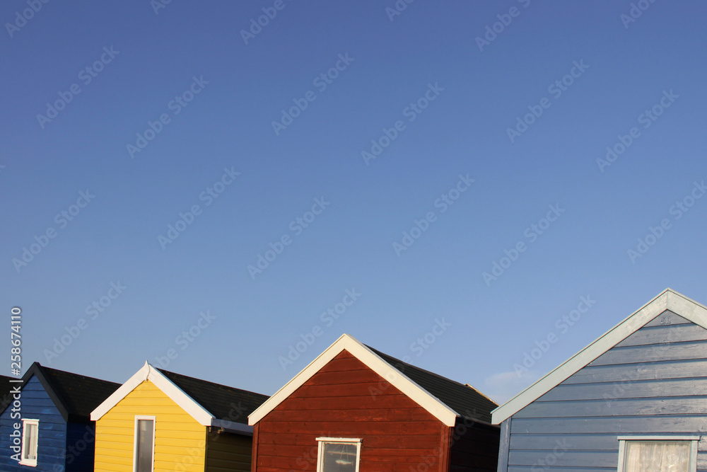 Colorful English beach huts against a blue sky