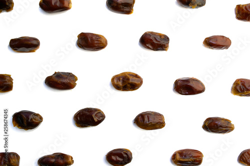 sweet dried dates laid out in several rows on a white background