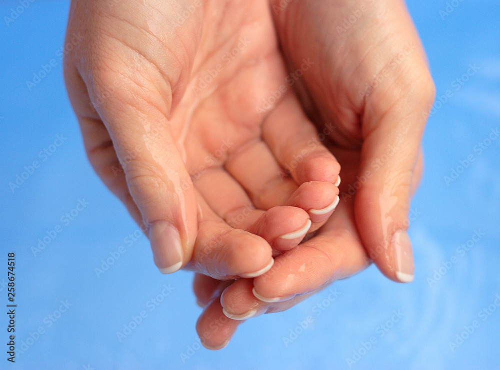 Washing hands in water, macro, blue background Washing hands in water, macro, blue background
