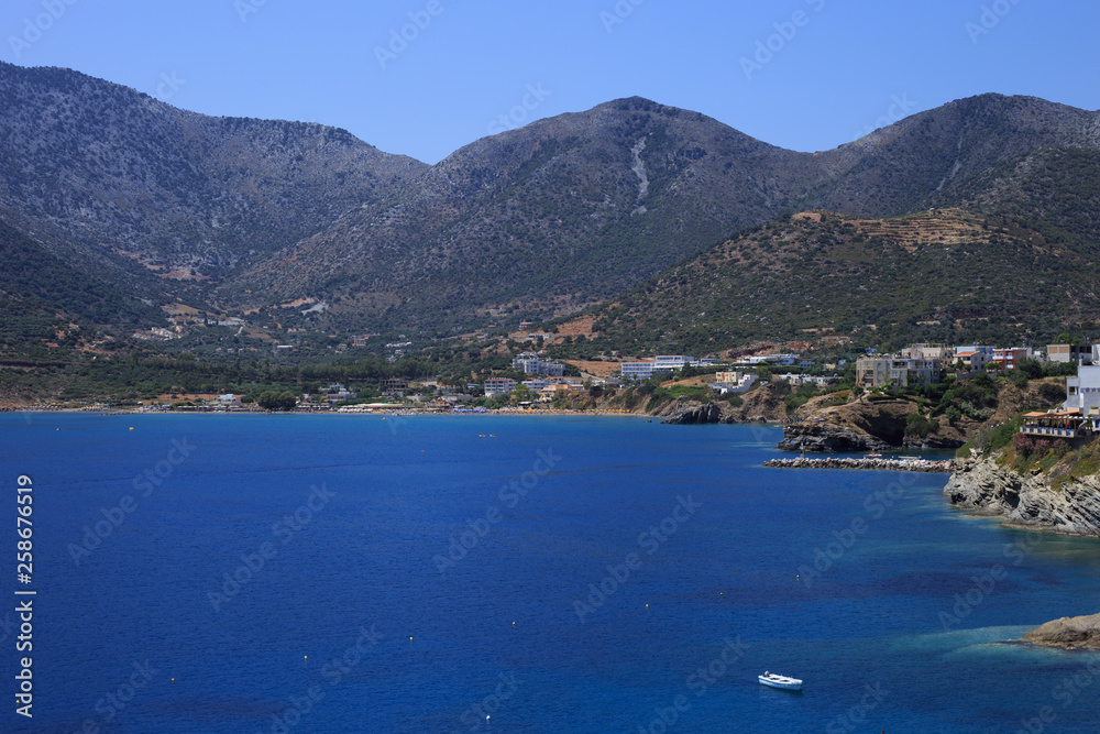 Sea Bay of resort village Bali. Views of mountain, shore, washed by waves and sun loungers. Bali, Rethymno, Crete, Greece