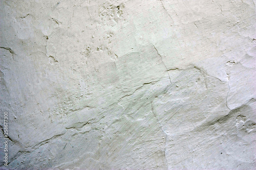 Old cracked whitewashed wall of the wattle and daub house. Close up photo