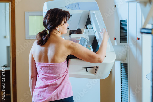 Female patient undergoing mammography test in hospital. Back view, selective focus photo