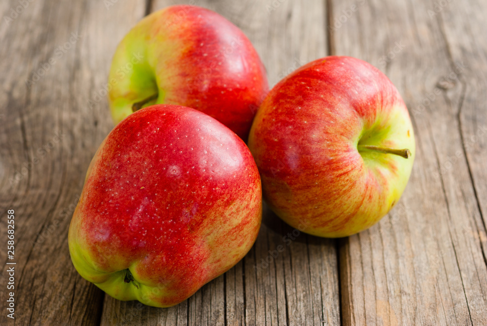 three apples on old wooden background three apples on old wooden background