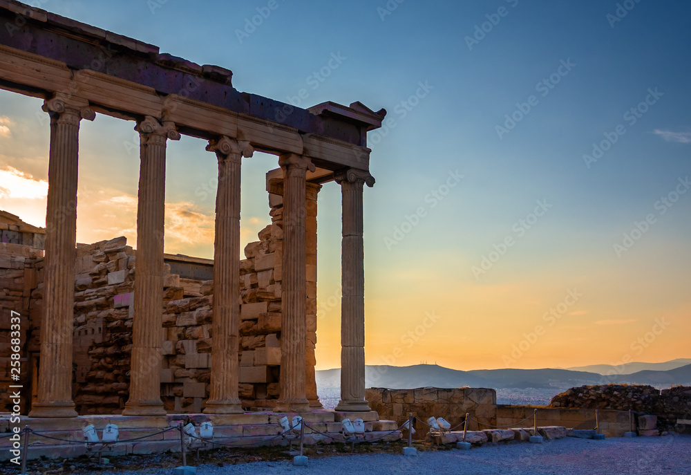 View of Erechtheion on Acropolis, Athens, Greece, against sunset overlooking the city