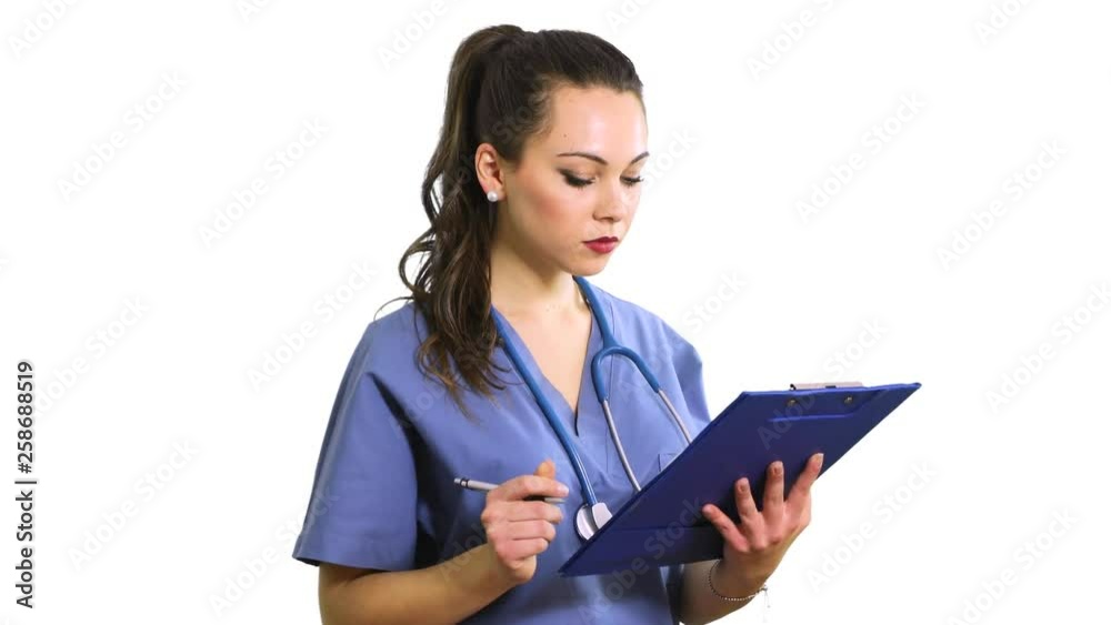 Female nurse reading documents on a clipboard Female nurse reading documents on a clipboard