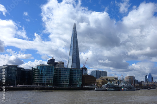 Photo from iconic skyscraper "the Shard" tallest building in Europe as seen in City of London with beautiful clouds and blue sky, London, United Kingdom